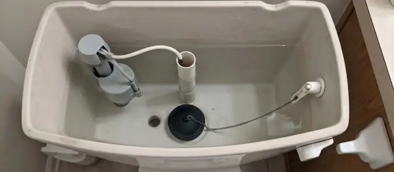 Inside of a toilet tank with a fill valve, flapper and overflow tube